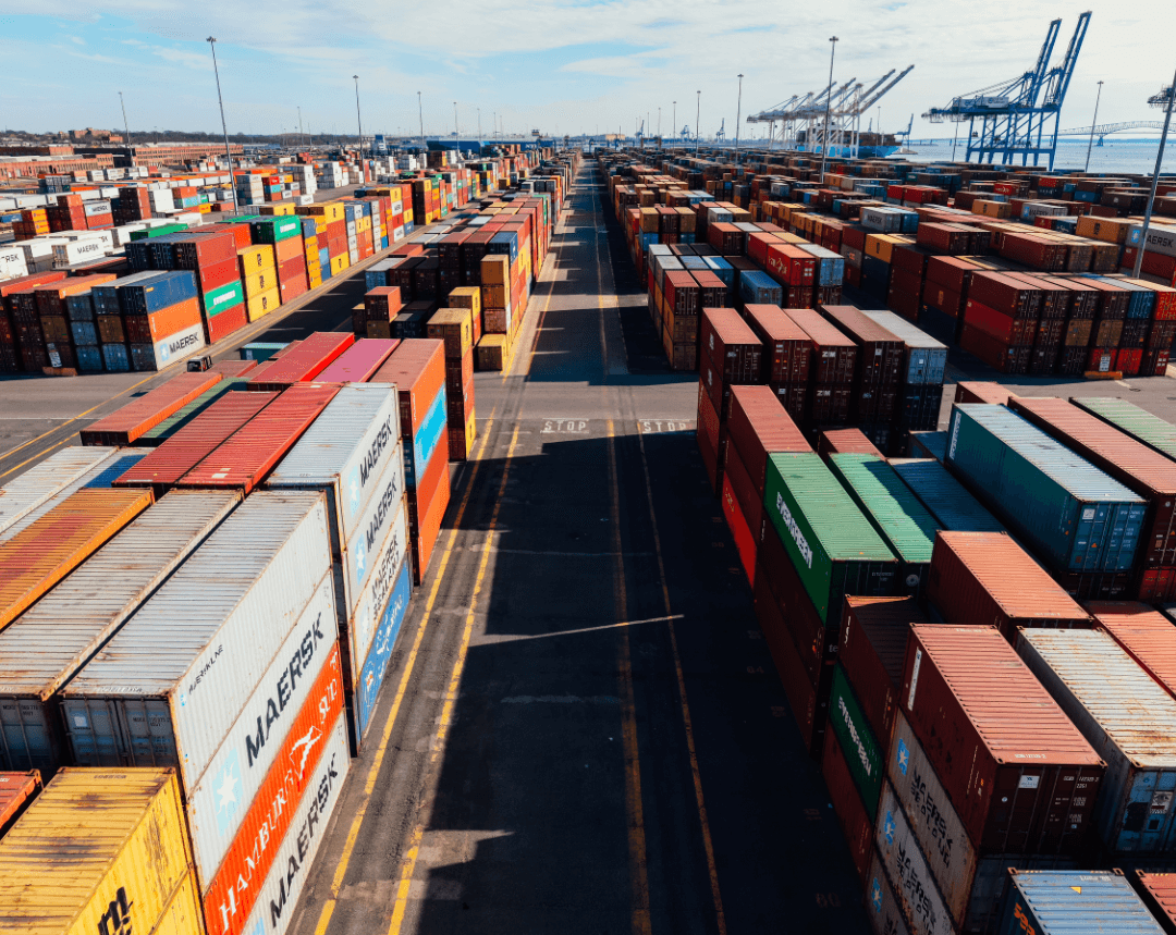 Blue shipping containers in organized rows at logistics facility